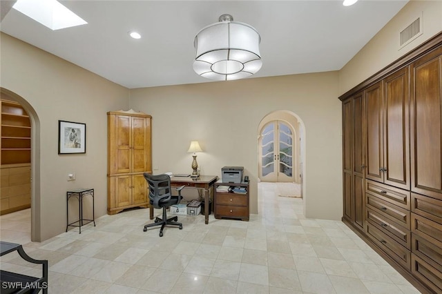 office area with a skylight, recessed lighting, visible vents, and arched walkways