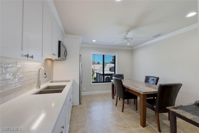 dining space with light tile patterned floors, a ceiling fan, baseboards, and ornamental molding