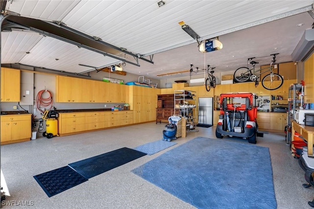 garage with a garage door opener and freestanding refrigerator