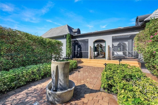 entrance to property with a patio area and stucco siding