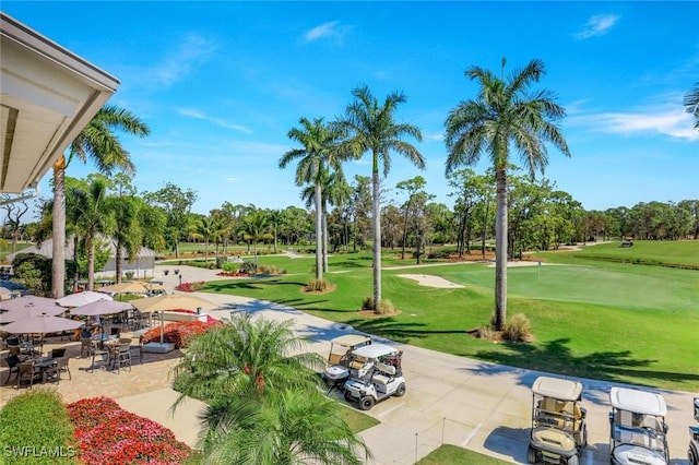 view of home's community featuring a lawn and view of golf course