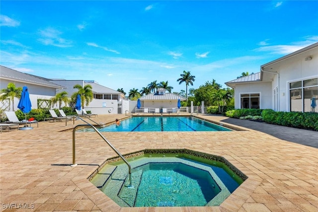 community pool featuring fence, a community hot tub, and a patio area