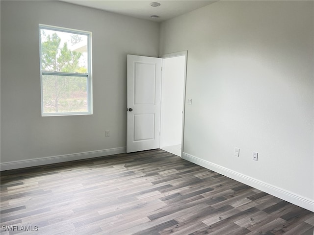 spare room with wood finished floors and baseboards