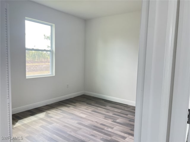 unfurnished room featuring baseboards and wood finished floors