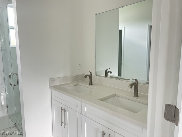 full bathroom with a sink, a marble finish shower, and double vanity