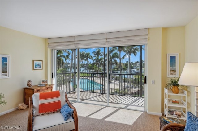 living area featuring plenty of natural light, baseboards, and carpet floors