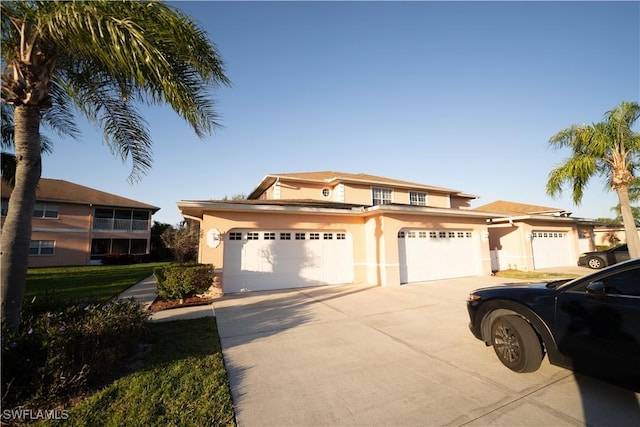 view of front of property with a garage, driveway, and stucco siding