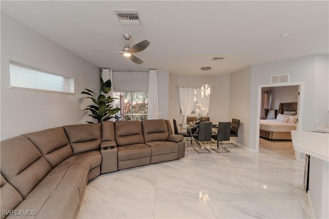 living room with ceiling fan with notable chandelier, visible vents, and marble finish floor