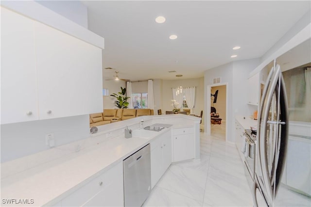 kitchen featuring marble finish floor, recessed lighting, appliances with stainless steel finishes, white cabinets, and light countertops