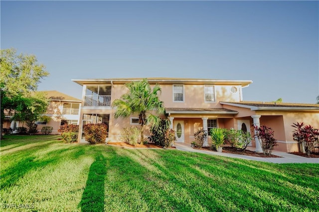 view of front of house featuring stucco siding and a front lawn