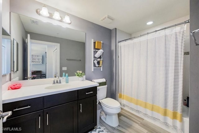 bathroom featuring visible vents, shower / bath combination with curtain, toilet, and vanity