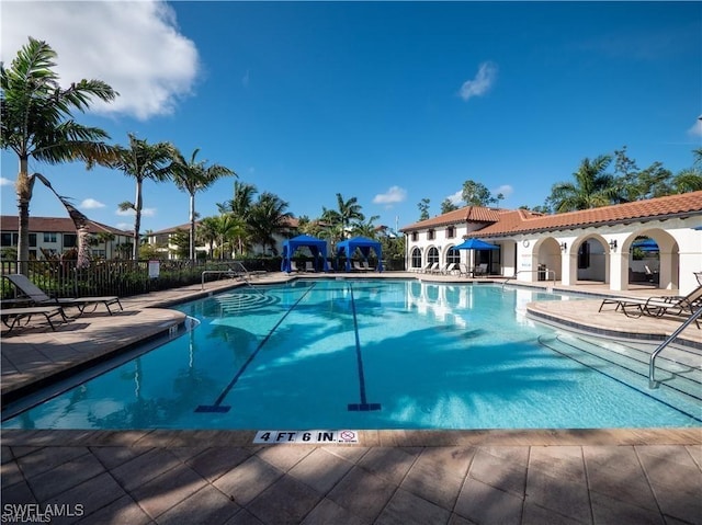 pool with fence and a patio area