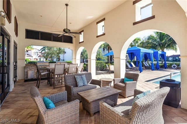 view of patio with area for grilling, ceiling fan, outdoor dining area, a community pool, and outdoor lounge area