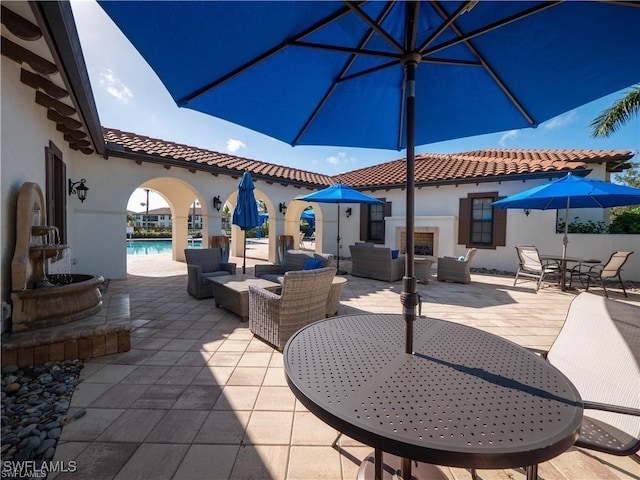 view of patio with a community pool, outdoor dining area, and an outdoor living space