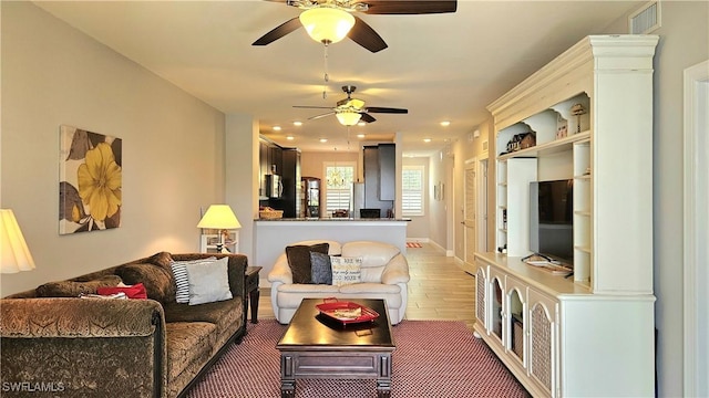 living room with visible vents, wood finished floors, baseboards, ceiling fan, and recessed lighting