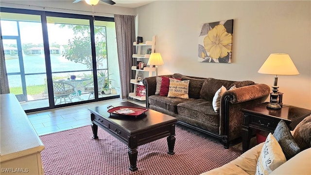 living area with a water view and ceiling fan