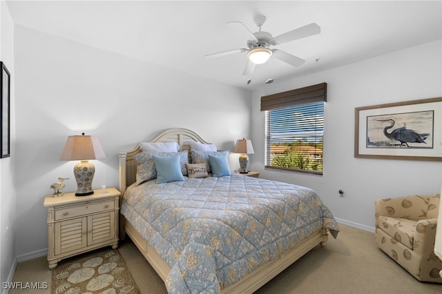 bedroom featuring light colored carpet, baseboards, and ceiling fan