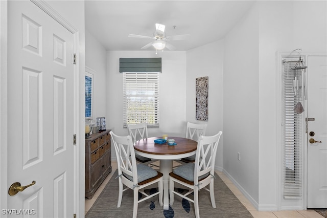 dining space with light tile patterned floors, baseboards, and ceiling fan