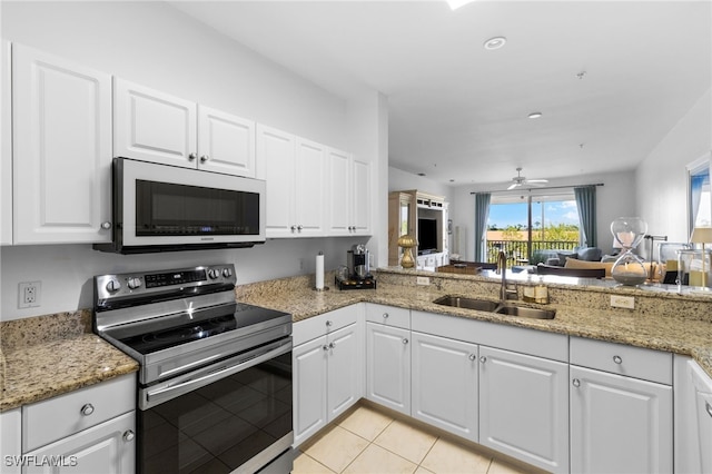 kitchen with electric range, a sink, open floor plan, white microwave, and ceiling fan