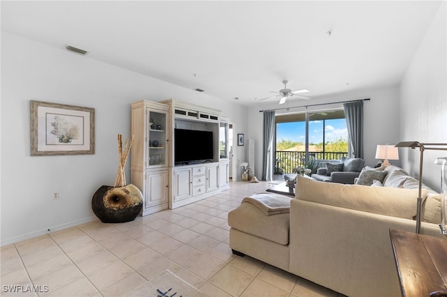 living area with light tile patterned floors, visible vents, baseboards, and ceiling fan