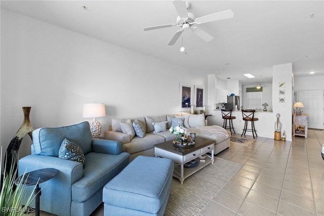 living area with tile patterned floors and a ceiling fan