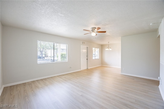4605 Bayshore Dr Unit G6, Naples, FL 34112 - spare room with a chandelier, a ceiling fan, light wood finished floors, and a textured ceiling