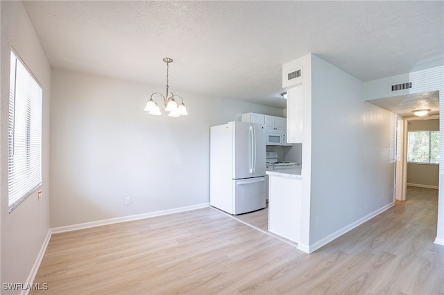 4605 Bayshore Dr Unit G6, Naples, FL 34112 - kitchen with white appliances, light wood finished floors, a chandelier, light countertops, and pendant lighting