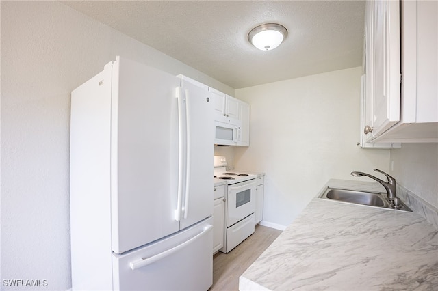 4605 Bayshore Dr Unit G6, Naples, FL 34112 - kitchen with white appliances, light wood-style floors, light countertops, white cabinetry, and a textured ceiling