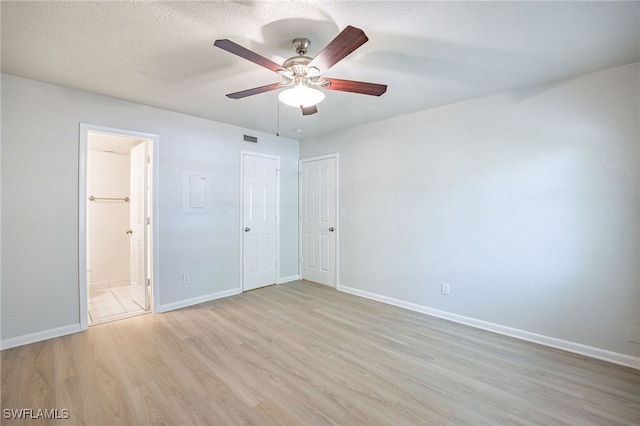 4605 Bayshore Dr Unit G6, Naples, FL 34112 - unfurnished bedroom with light wood finished floors, ensuite bath, a closet, a ceiling fan, and a textured ceiling
