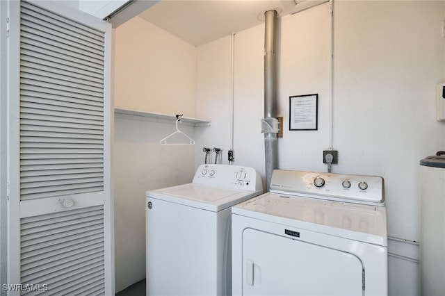 washroom featuring water heater, laundry area, and washing machine and clothes dryer