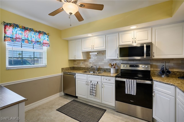 kitchen featuring decorative backsplash, appliances with stainless steel finishes, white cabinetry, and a sink