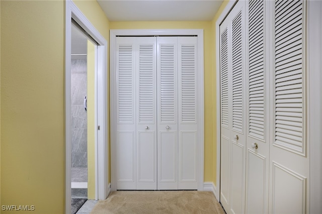 hall featuring light colored carpet