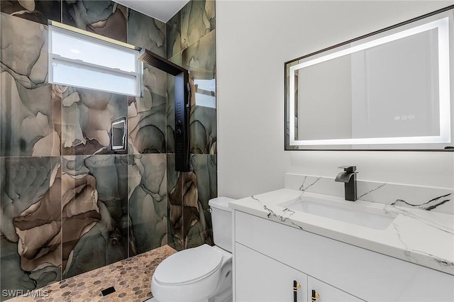 bathroom with tiled shower, toilet, and vanity