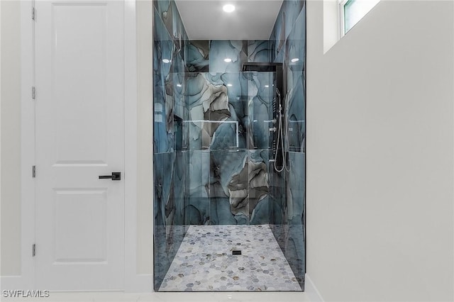 bathroom featuring a marble finish shower