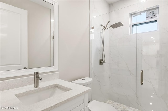 full bath with vanity, toilet, and a marble finish shower