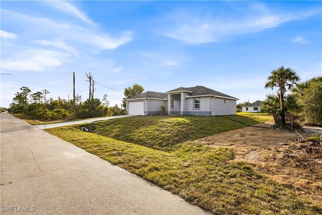 view of front of house with a front yard, a garage, driveway, and stucco siding