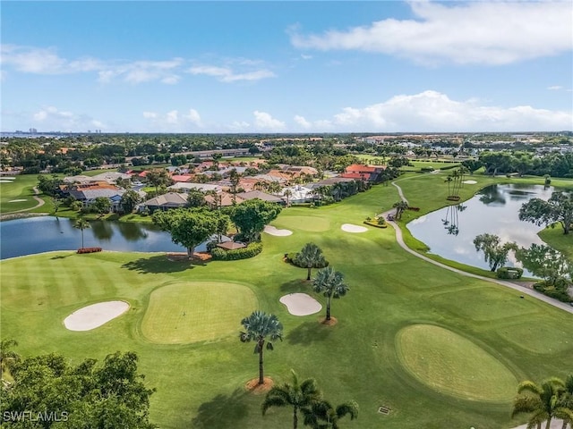 drone / aerial view with golf course view and a water view