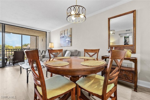 dining area featuring baseboards, visible vents, ornamental molding, a notable chandelier, and light wood-type flooring