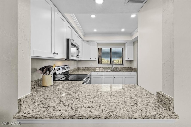 kitchen with crown molding, light stone countertops, stainless steel appliances, white cabinetry, and a sink