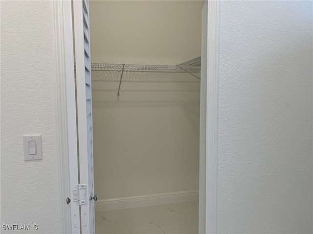 spacious closet featuring marble finish floor