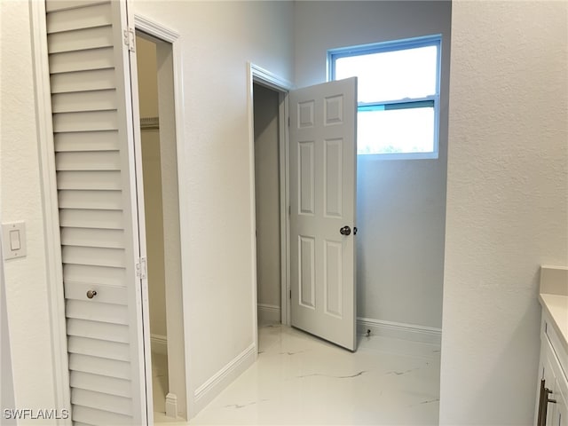 bathroom featuring marble finish floor, vanity, and baseboards