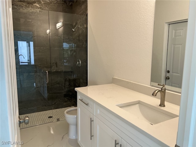 bathroom featuring a marble finish shower, toilet, and vanity