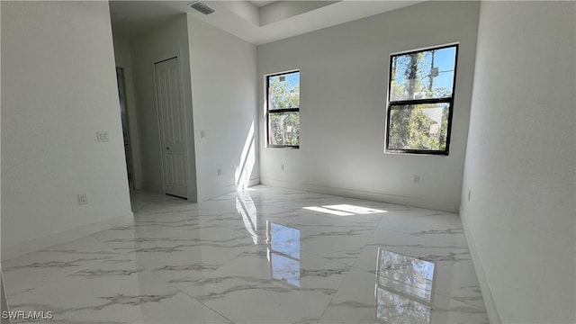 empty room featuring visible vents, marble finish floor, and baseboards