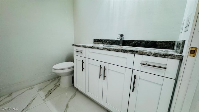 bathroom with baseboards, toilet, marble finish floor, and vanity