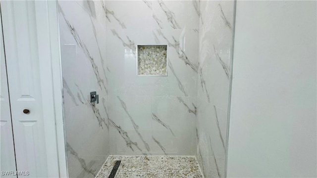 bathroom with a marble finish shower