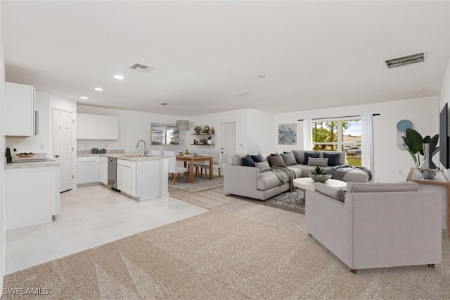 living area with recessed lighting, visible vents, and light colored carpet