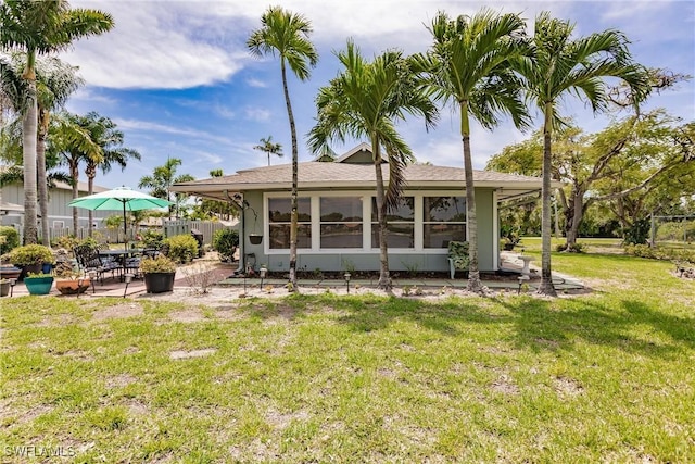 rear view of property with a patio area, a yard, and fence