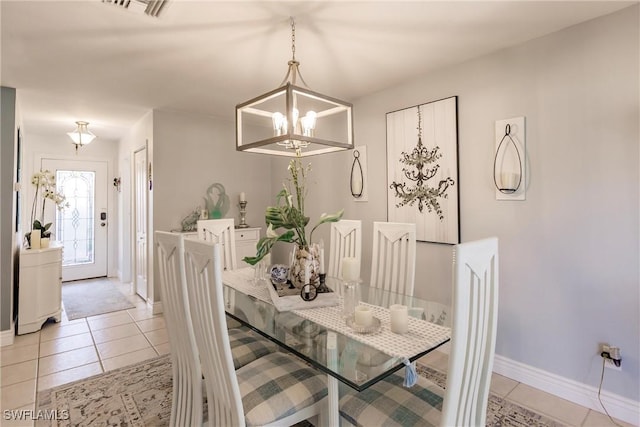 dining room featuring light tile patterned floors, a notable chandelier, visible vents, and baseboards