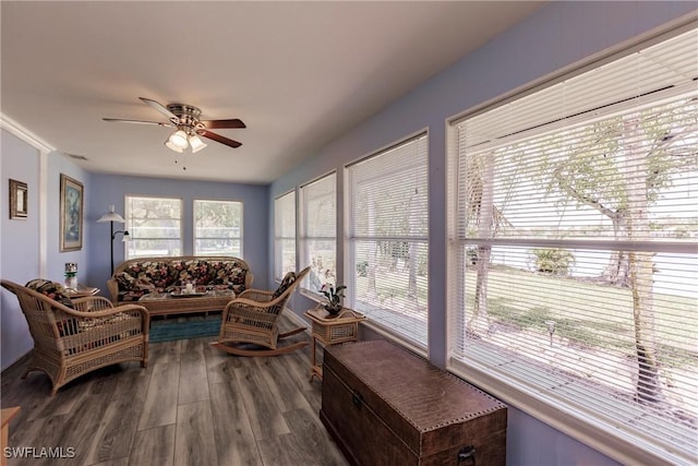 living area featuring dark wood finished floors, a healthy amount of sunlight, and ceiling fan