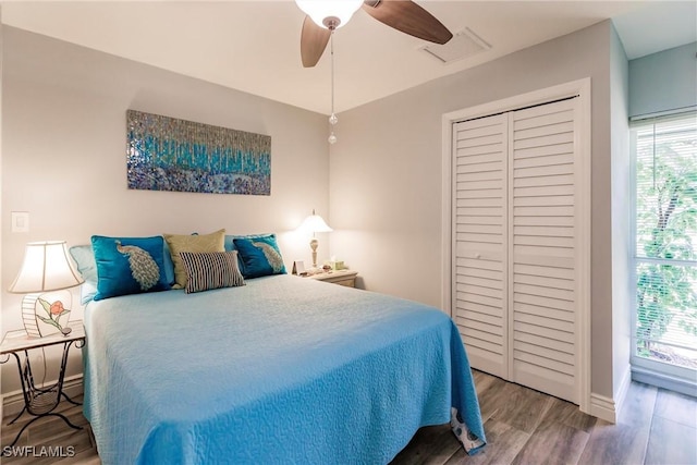 bedroom featuring visible vents, baseboards, wood finished floors, a closet, and a ceiling fan